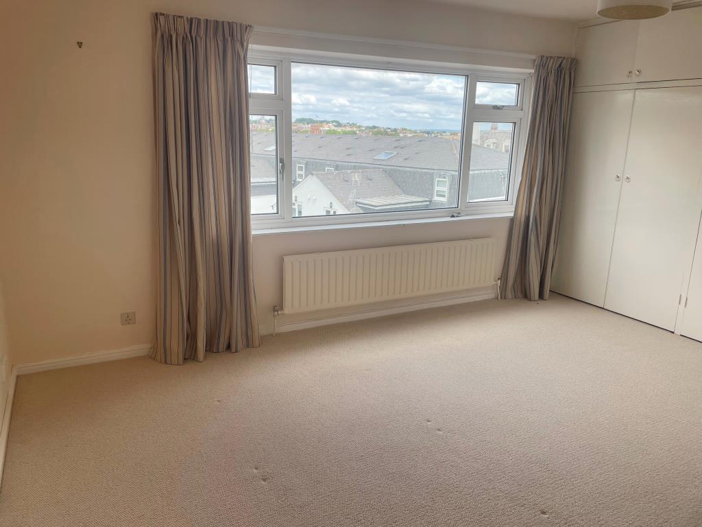 Lot: 156 - TWO-BEDROOM FLAT WITH SEA VIEWS - Main bedroom with wardrobes and view of town